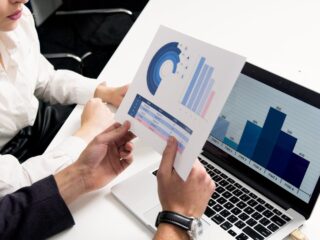 Business professionals discussing data charts and graphs in a modern office setting.