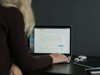woman in black sweater using macbook pro