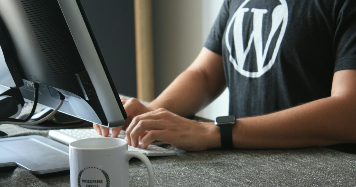 person in black and white t-shirt using computer